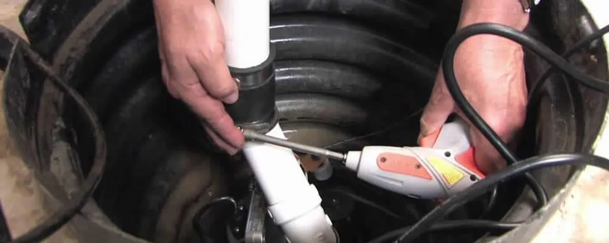 Sump pump installation technician connecting PVC discharge piping in Virginia Beach, VA